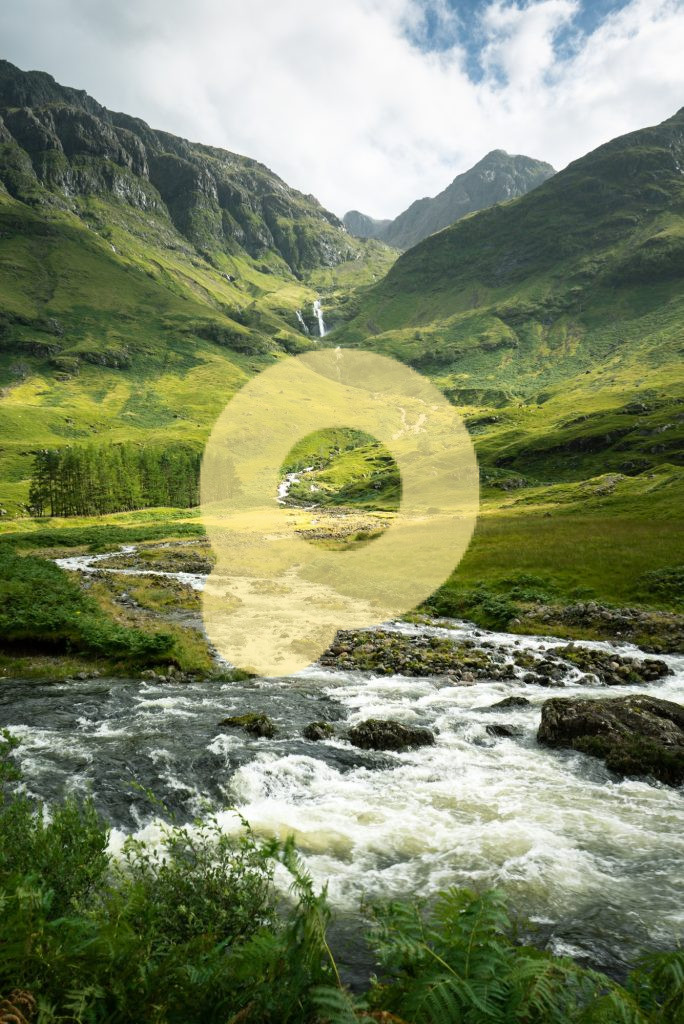 Вертикальный снимок реки, окруженной горами и лугами Шотландии