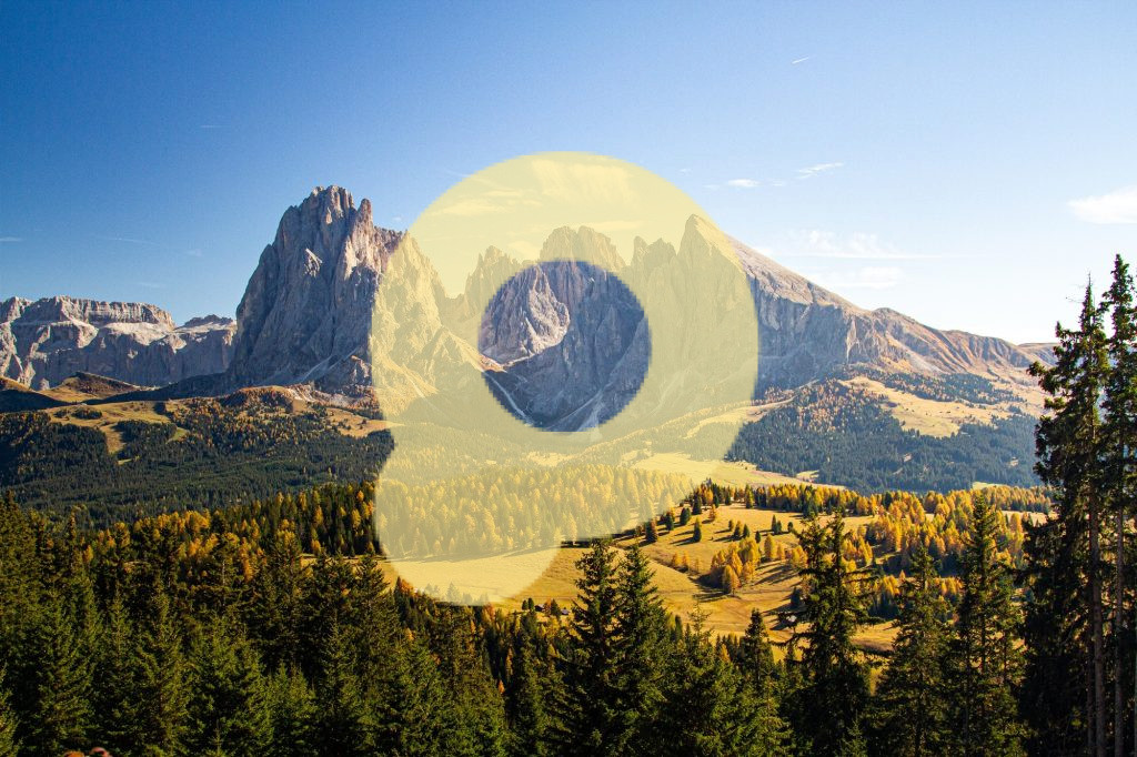 Травянистые холмы, покрытые деревьями, рядом с горами Доломитовые Альпы, Италия